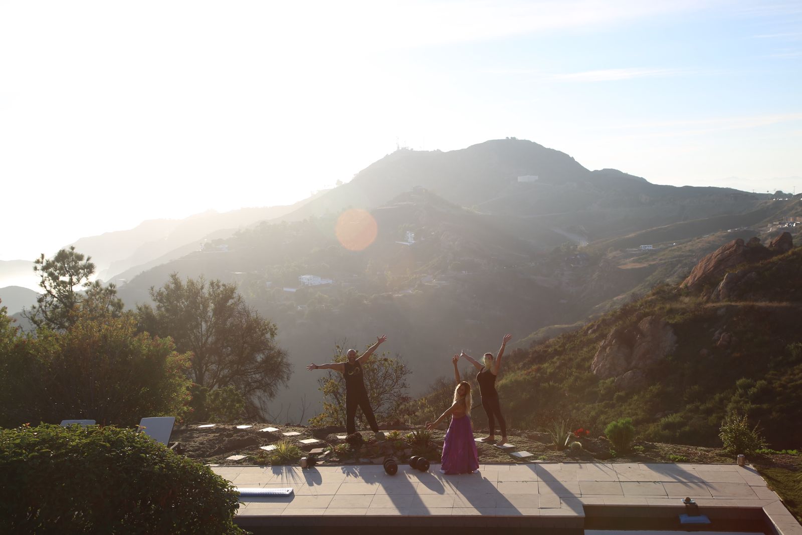 Arms raised on the rooftop terrace at golden hour — Casa Topanga